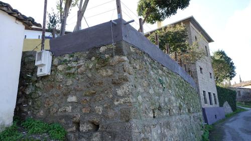 a stone wall with a cross on top of it at The old olive mill house in Aegae