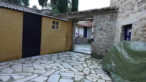 an entrance to a building with a green tarp on it at The old olive mill house in Aegae