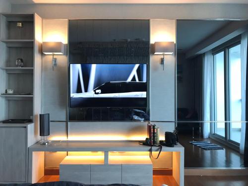a living room with a tv on a wall at Luxurious Beachfront Pattaya in North Pattaya