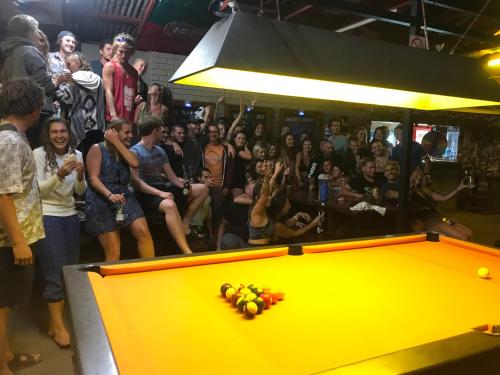 a crowd of people standing around a pool table at Cable Beach Backpackers in Broome