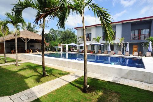 um resort com piscina e palmeiras em Tamarind em Panglao