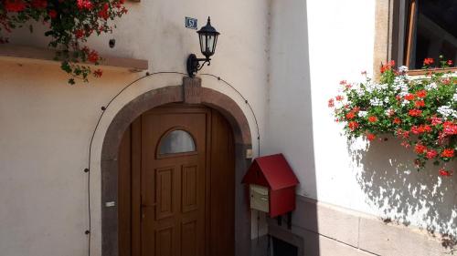 een ingang naar een gebouw met een deur en bloemen bij Le moulin des automates in Fréland