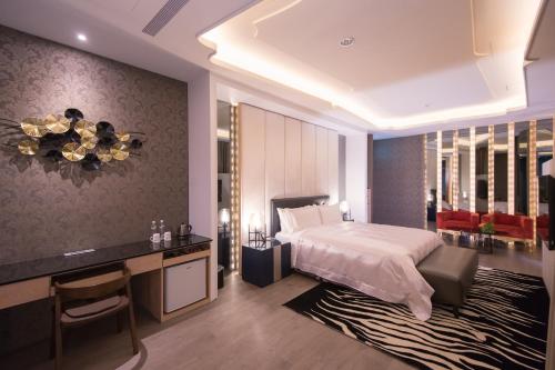 a hotel room with a bed and a desk and a desk at J Moon Villa Motel in Taipei