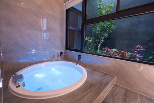 a large bath tub in a bathroom with a window at J Moon Villa Motel in Taipei