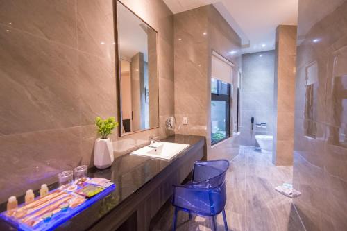 a bathroom with a sink and a mirror and a tub at J Moon Villa Motel in Taipei