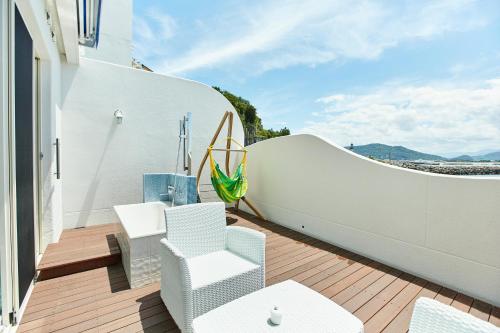 a balcony with white chairs and a fence at Wakanoura Nature Resort Epicharis in Wakayama