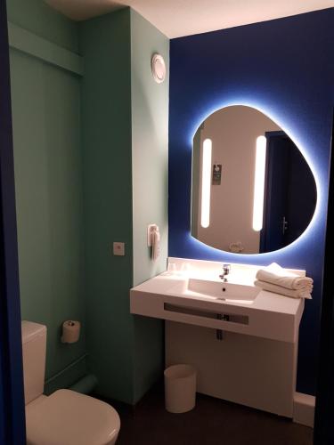 a bathroom with a sink and a mirror at Ibis Budget Saint Christol Les Alès in Saint-Christol-lès-Alès