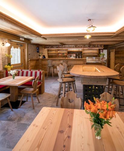 a restaurant with wooden tables and chairs and benches at Agriturismo Malga Piè in Soraga