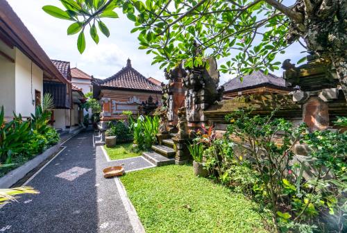 a courtyard of a house with a garden at Gatra Ubud Inn in Ubud
