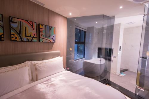 1 dormitorio con cama, ducha y lavamanos en J Moon Villa Motel en Taipéi