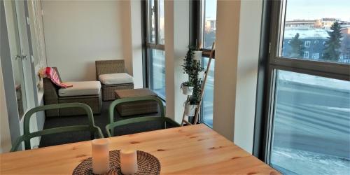 a dining room with a table and chairs and a balcony at Kotimaailma Apartments Oulu in Oulu
