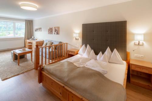 a bedroom with a large bed with a large headboard at Dilly - Das Nationalpark Resort in Windischgarsten