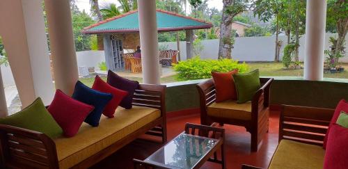a patio with colorful chairs and a table at Ahangama Eco Villa in Ahangama