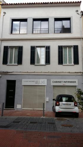 um edifício branco com um carro estacionado em frente em 35 ter rue du Docteur Marçon em Bandol