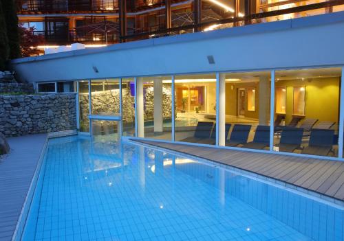 a swimming pool in front of a building at night at Feldmilla Design Hotel - Wellness & SPA in Campo Tures