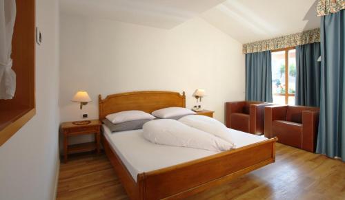 a bedroom with a bed with white sheets and pillows at Feldmilla Design Hotel - Wellness & SPA in Campo Tures