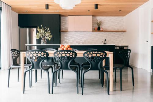 una cocina con mesa negra y sillas negras en Laneway Apartments - Orientem, en Port Fairy