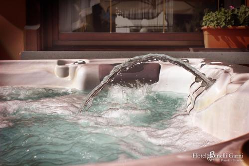 a faucet in a sink with water coming out at Hotel Binelli in Pinzolo