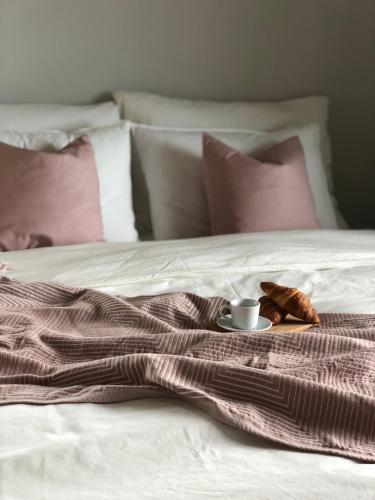 a blanket with a cup of coffee and croissants on a bed at Vigna Rocchetta in Cassinasco