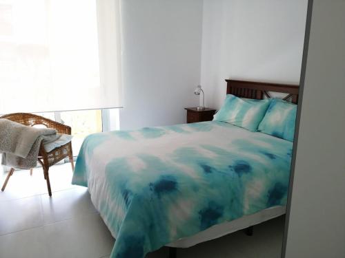 巴哈馬爾的住宿－Apartamento en Bajamar -Tenerife，卧室配有床、椅子和窗户。