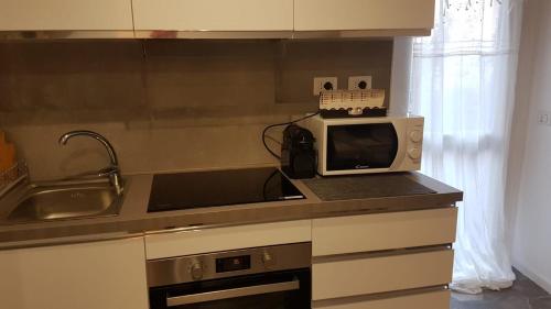 a kitchen counter with a microwave and a sink at Varenna Sweet Home in Varenna