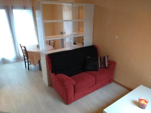 a living room with a red couch and a table at T1Bis Central Blagnac in Blagnac