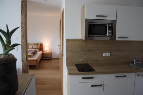 a kitchen with a microwave and a living room at Bed & Breakfast in Haag am Hausruck