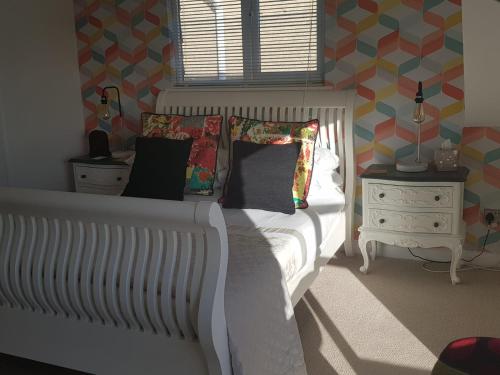 a bedroom with a white bed and a window at Telscombe Cliffs Bed and Breakfast in Rottingdean