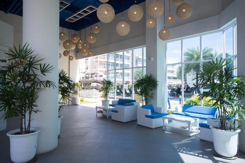 a lobby with blue chairs and potted plants in a building at Grandblue Condominium 708 in Ban Nam Lai Ta Tum