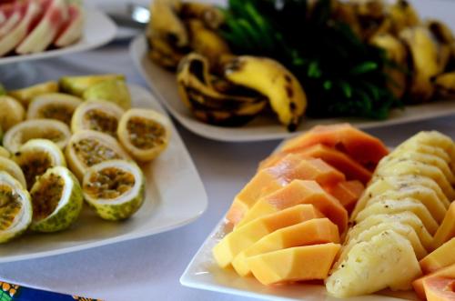 a table with three plates of fruit on plates with bananas at Amaan Beach Bungalows in Nungwi