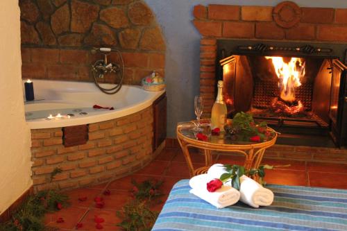 a bath room with a fireplace and a table with towels at Casas Cueva Cazorla in Hinojares