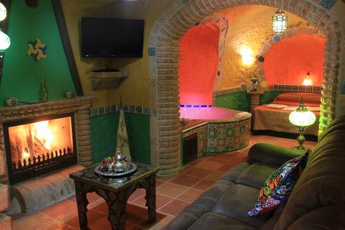 a living room with a fireplace and a bedroom at Casas Cueva Cazorla in Hinojares