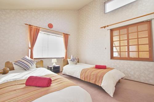 una camera con due letti e una finestra di Villent Fujimi Hiekawa a Izu