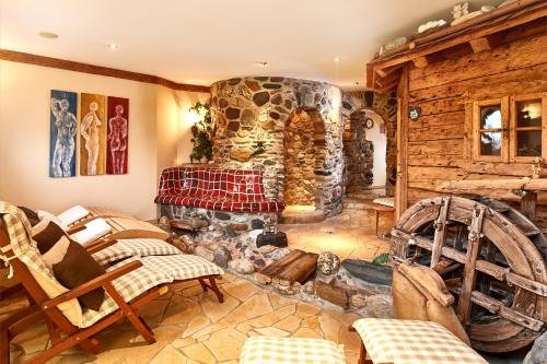 a living room with a stone fireplace and chairs at Bio-Pension Bliem in Altenmarkt im Pongau