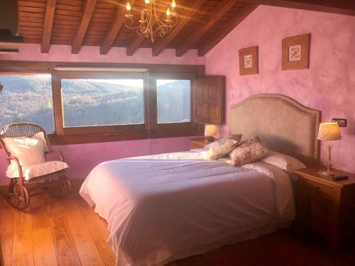 a bedroom with a bed and a chair and a window at Casa Rural Amparo in Mogarraz