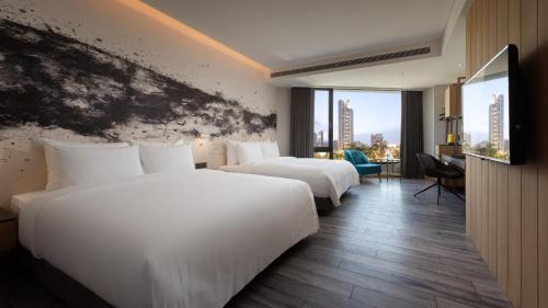 a hotel room with two beds and a large window at Brio Hotel in Kaohsiung