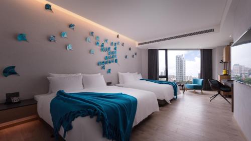 a hotel room with two beds with blue sheets at Brio Hotel in Kaohsiung