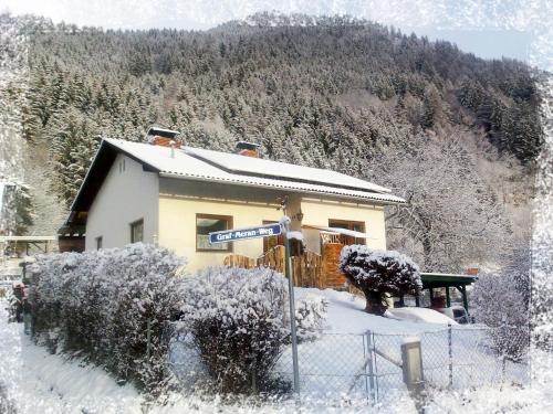 a house in the snow with a sign on it at Ferienhaus Weiss in Lind bei Scheifling
