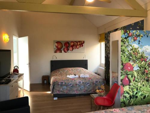 1 dormitorio con 1 cama y una pintura de manzanas en la pared en Cozy Bed and Breakfast en Elst