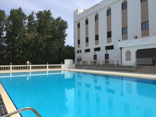 einem großen Pool vor einem Gebäude in der Unterkunft Hotel Al Madinah Holiday in Muscat