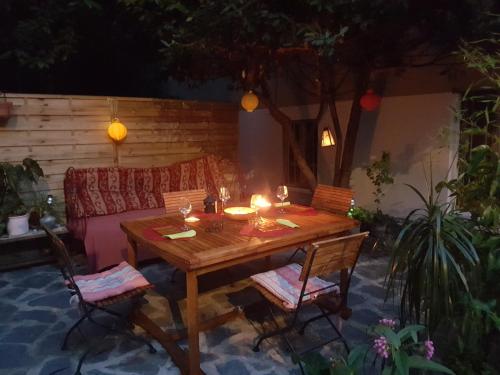 een houten tafel met 2 stoelen en een bank bij Maison Atypique au pied du château in Montélimar