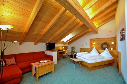 uma sala de estar com um sofá vermelho e uma cama em Landgasthof Zur Post em Schwangau