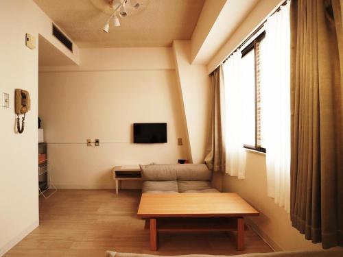 a living room with a couch and a tv at 新大阪徒步30秒 Shinosaka Station 30s, Direct to Kansai Airport 關西空港直達, Shinkansen to Kyoto, Tokyo & Nagoya, Universal Studio 16 mins, Umeda 6 mins, Kyoto 25 mins, Early Check in in Osaka