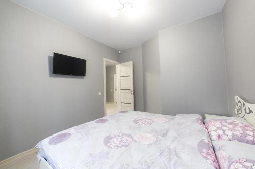 a bedroom with a bed and a flat screen tv at Apartments near Dolphinarium in Truskavets