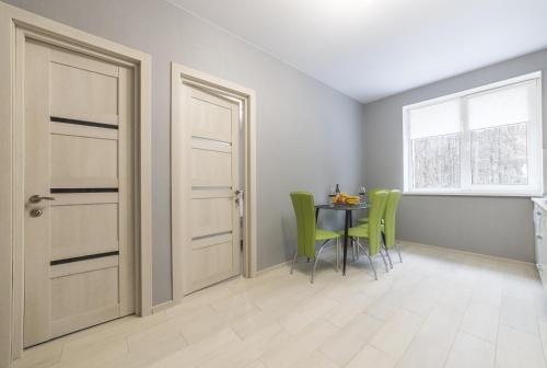 a room with a door and a table with green chairs at Apartments near Dolphinarium in Truskavets