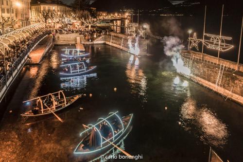 a group of boats in the water at night at La Casa Rosa by Roby&Silvy in Bellano