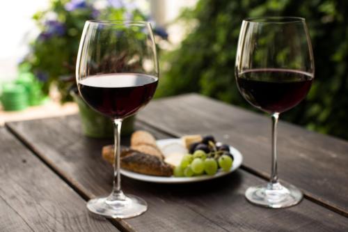 two glasses of wine and a plate of food on a wooden table at Hotel Perler Hof in Perl