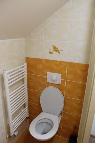 a bathroom with a toilet with a bird on the wall at Buchtův statek in VendolÃ­