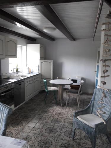 a kitchen with a table and chairs and a table at Zimmer vor Sylt und Dänemark in Klanxbüll