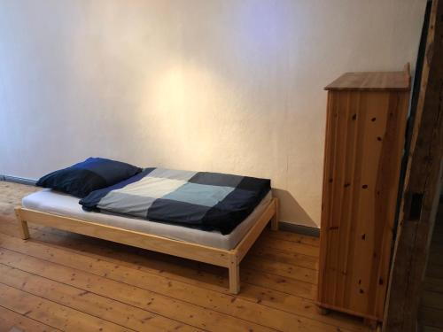 ミュールハウゼンにあるFerienwohnung am Leimsiederturmのベッドルーム1室(ベッド1台付)、木製キャビネットが備わります。